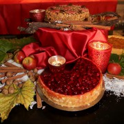 Zwei Torten auf weihnachtlich dekoriertem Tisch mit Kerzen, Walnüssen und Weinblättern